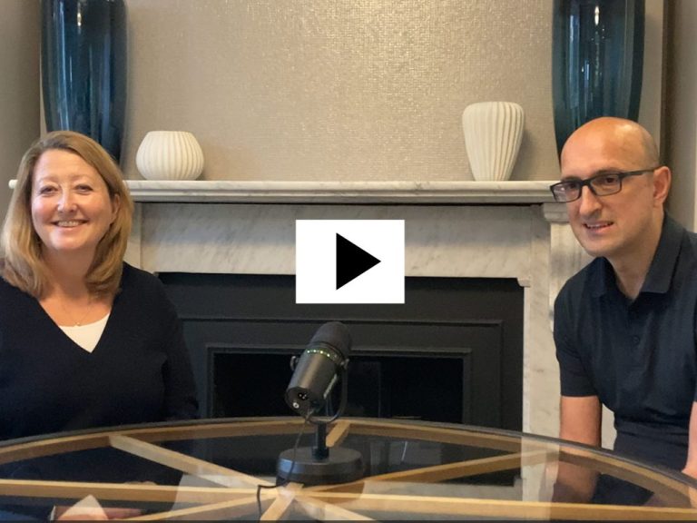Helen Deavin and Matthew Syed sat down talking with microphone in front of a fireplace