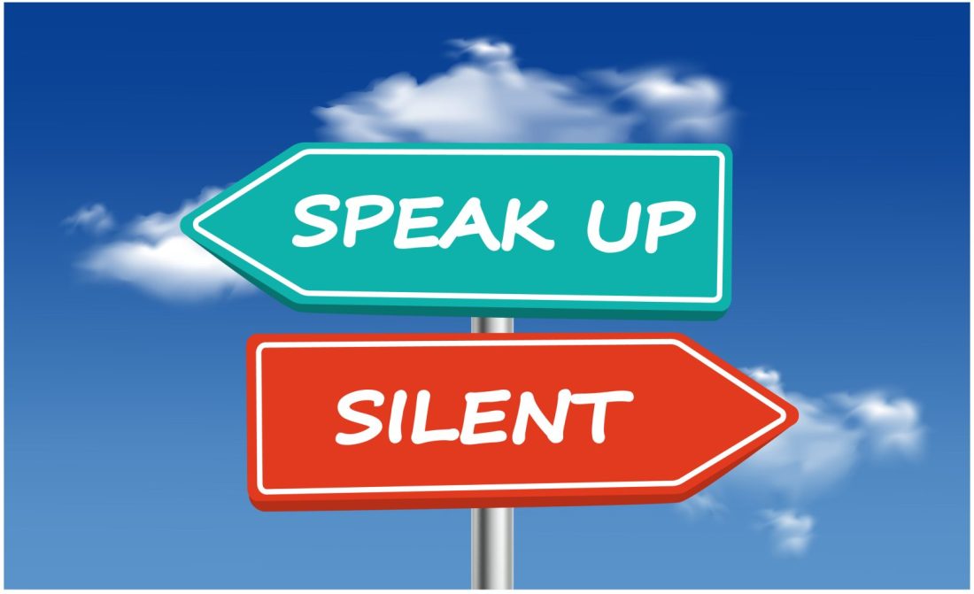 A picture of a sign post with two signs, one says "Speak Up" the other says "Silent"