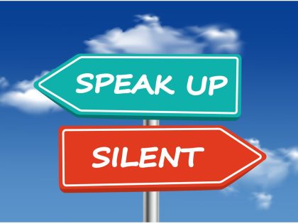 A picture of a sign post with two signs, one says "Speak Up" the other says "Silent"
